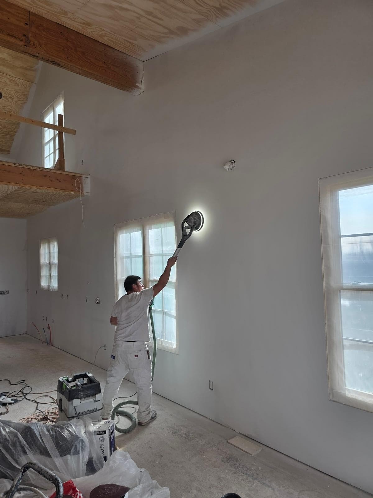 Mission Painting crew member performing Festool HEPA vacuum sanding on interior surfaces